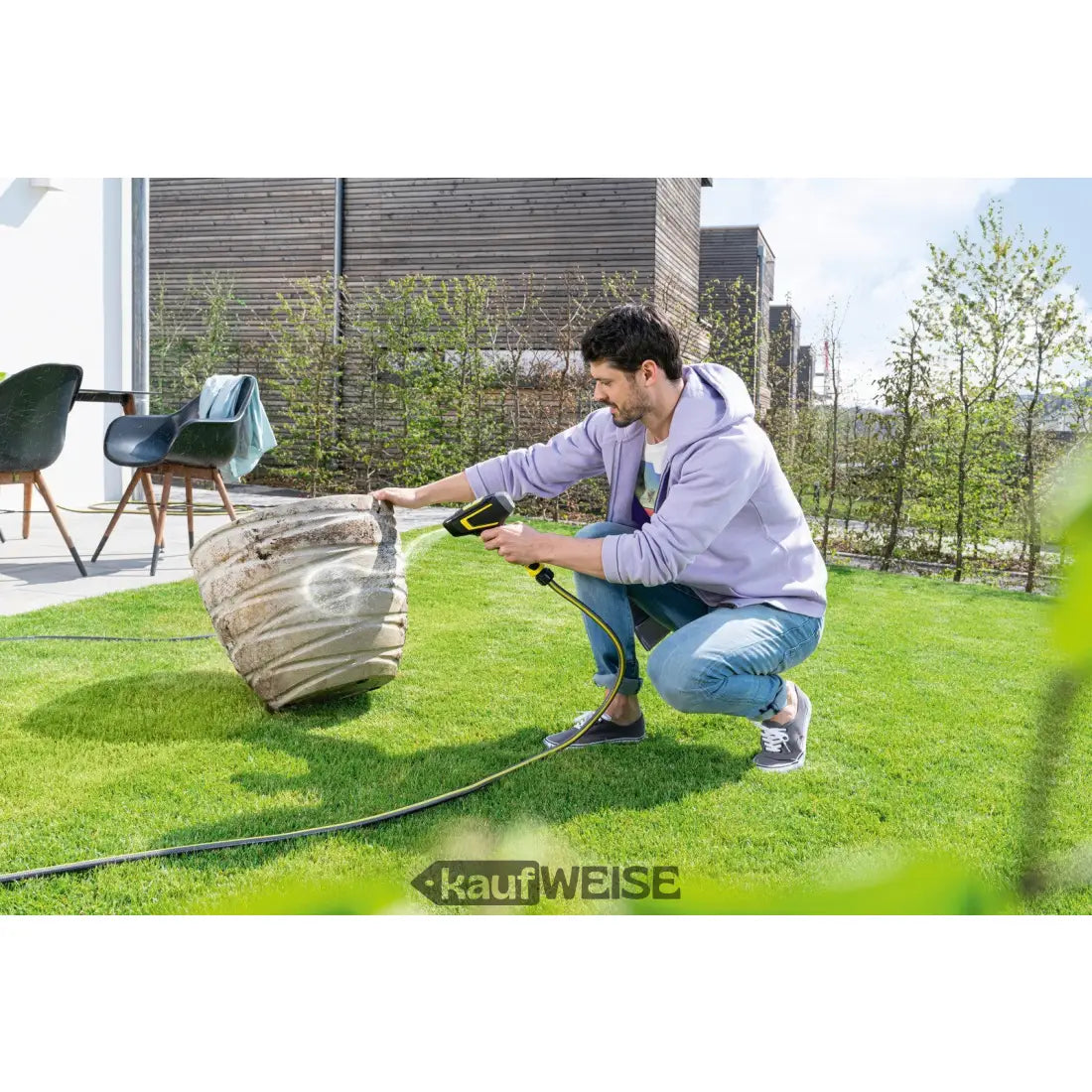 Mann reinigt großen alten Pflanzkübel mit Kärcher WBS 3 Druckpistole